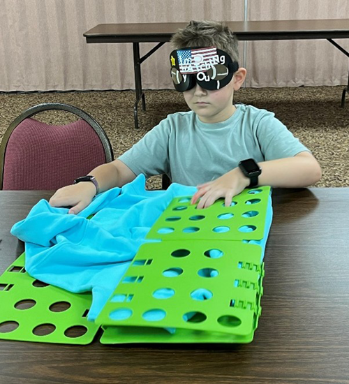 2024 campers learning to fold shirt