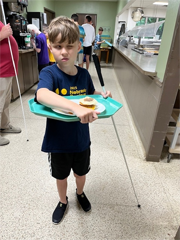 camper carrying tray in dining hall