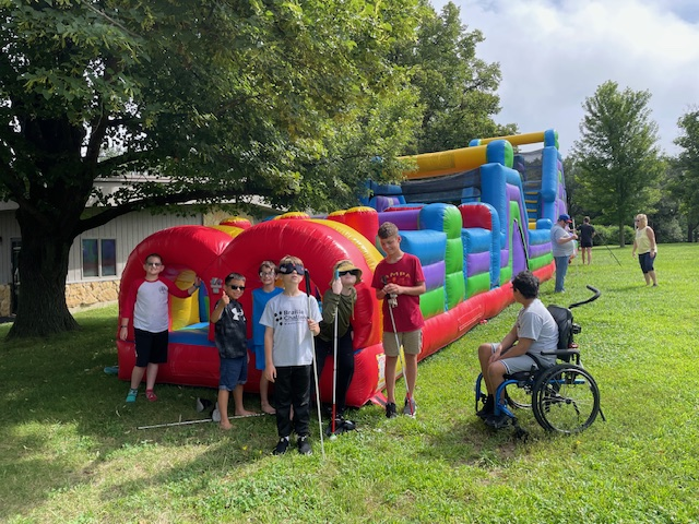 campers in front of large inflatable obstacle course