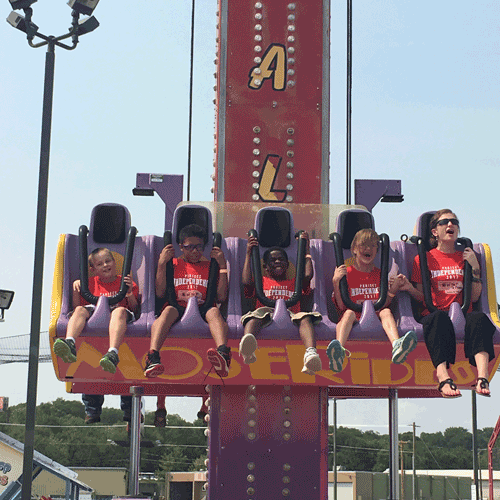 Students beaming widely on Free Fall amusement ride